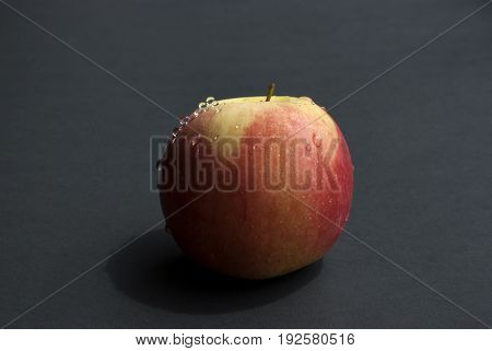 Ripped apple with waterdrops in a black  background