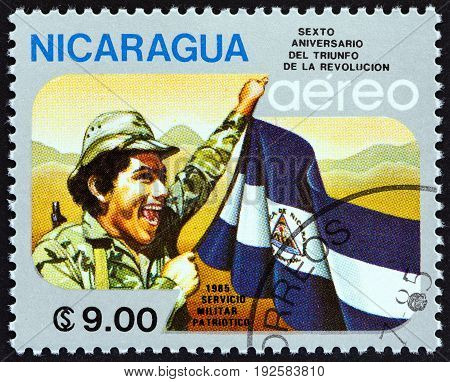 NICARAGUA - CIRCA 1985: A stamp printed in Nicaragua issued for the 6th anniversary of Revolution shows soldier and flag, circa 1985.