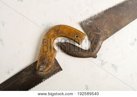Large Teeth Of An Old Saw On Wood. Sharp And Uneven Edges. Rusted Surface. Light Stone Background.