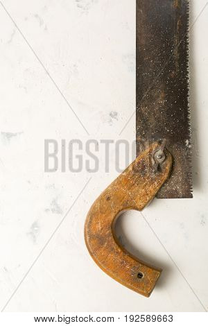 Large Teeth Of An Old Saw On Wood. Sharp And Uneven Edges. Rusted Surface. Light Stone Background.