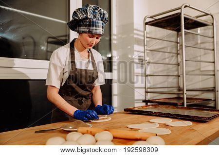 Making cinnamon buns. Homemade raw yeast dough after raising ready to bake, a Baker making cinnamon rolls
