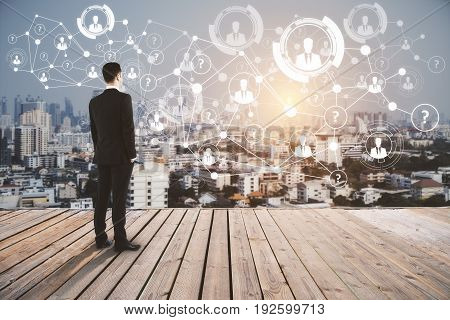 Young businessman on pier looking at city with HR network. Recruting concept