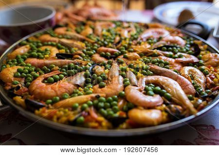 Seafood paella in a frying pan is on the table
