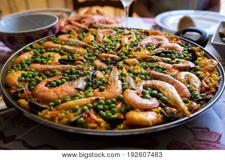 Seafood paella in a frying pan is on the table