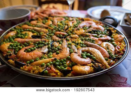 Seafood paella in a frying pan is on the table