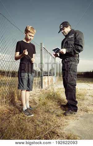 Police man questioning teenage pickpocket out of city