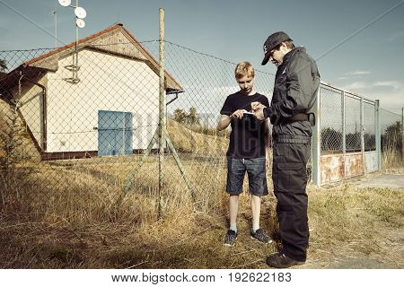 Police man questioning teenage pickpocket out of city