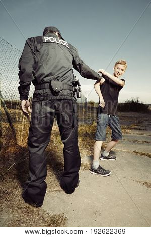 Teenager fighting with police man in fields