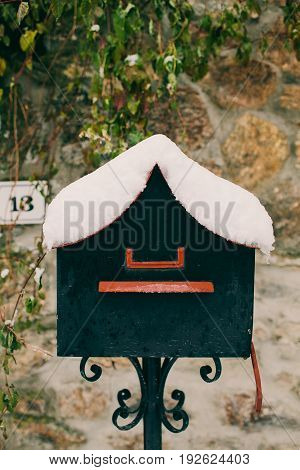 Vintage mailbox covered with snow. Post box background. Letterbox in vintage style. Old grey mailbox in stone background.