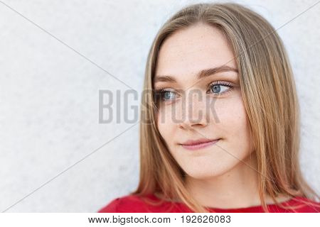 Close Up Portrait Of Pensive Woman With Light Hair, Blue Eyes And Freckles Looking Away Having Deep