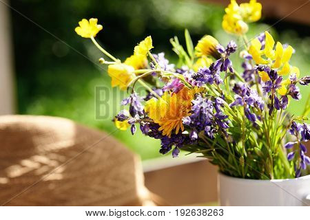wild flowers and summer srtaw hat at sunny day