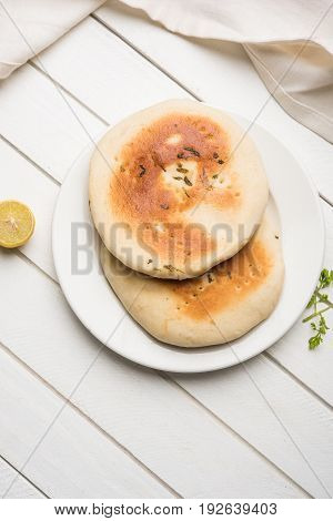 Kulcha is a type of leavened bread originated from the Indian Subcontinent; eaten in India and Pakistan, made from maida. Selective focus. Isolated