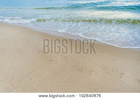 background image - blue and green waves crashing on the sandy shore