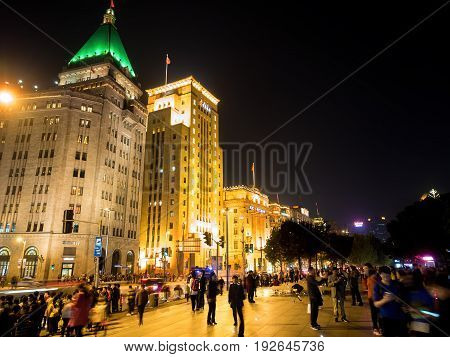 Shanghai, China - Nov 4, 2016: Night view of Sassoon House and Bank of China buildings (left to right) along The Bund on Zhongshan East 1st Road. Some haze can still be seen.