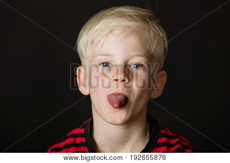 Playful Little Blond Boy Sticking Out His Tongue