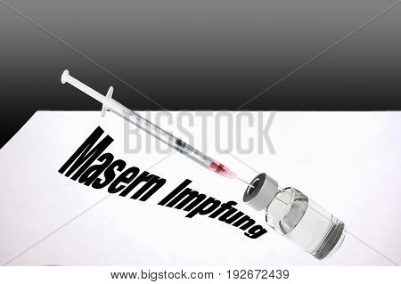 Close-up view a syringe and a bottle with medical fluid. Lettering in German 
