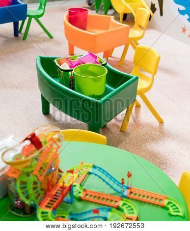 Plastic sand toy and buckets in play room. Creative and fun educational toy for kids.