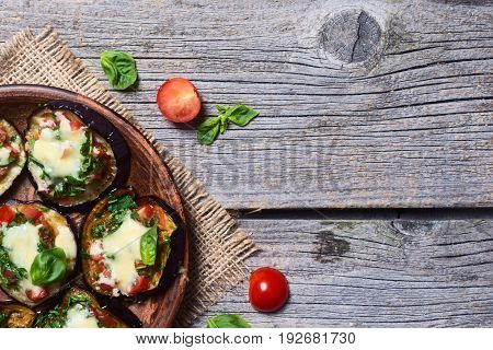 Mini pizza with eggplant tomato and basil . Top view