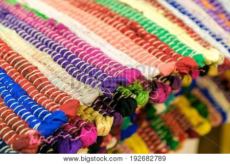 Colourful handmade rugs piled up on display at central market South Australia