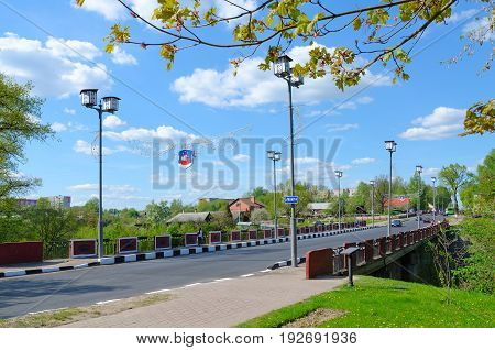 POLOTSK BELARUS - MAY 19 2017: Unknown people walk along Red Bridge across Polota River (monument of Patriotic War of 1812 on Polotchyna) Polotsk Belarus