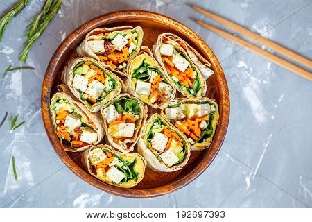 Healthy vegan tofu tortilla wraps with tofu and vegetables top view. Love for a healthy raw food concept.