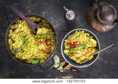 Indian Vegetable Biryani with Sweet Pepers and Zucchini as close-up in a frying pan