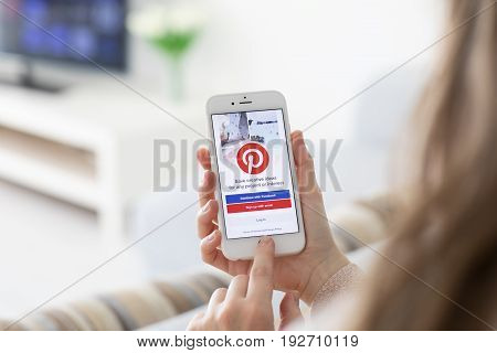 Alushta Russia - May 27 2017: Woman hands holding iPhone with social Internet service Pinterest on the screen. iPhone was created and developed by the Apple inc.