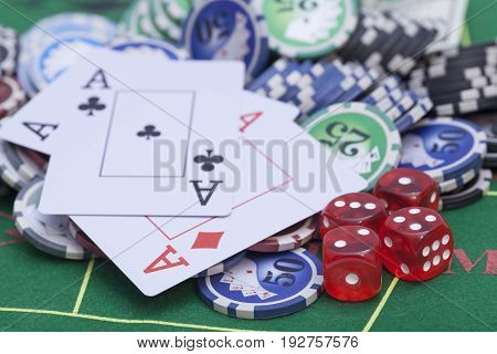 Casino chips cards and dices on green felt game table