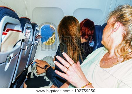 Interior of a modern airplane and passengers while charging at the airport of a holiday island in the south.