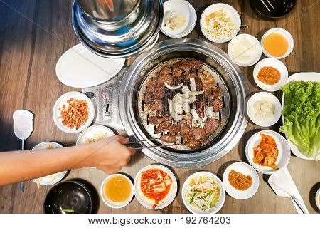 Person Barbecue Beef On Bbq Pit During Korean Meal Set