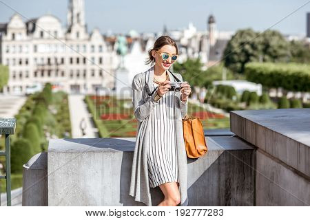 Young female traveler standing with photocamera on the famous Arts mountain with great view on the old city in Brussels