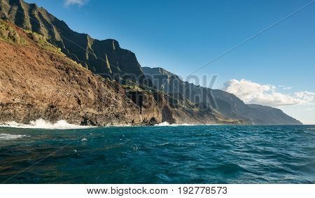 Kalalau trail path crosses steep ridge on Na Pali coastline in Kauai from sunset cruise