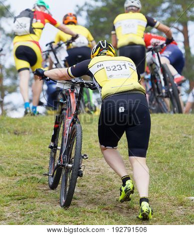 STOCKHOLM SWEDEN - JUNE 11 2017: Group of fighting male mountain bike cyclists leading cycle uphill at Lida Loop Mountain bike Race. June 11 2017 in Stockholm Sweden