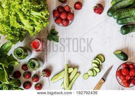 Top view. Fresh green smoothies and strawberry smoothie with ingredients on a light wooden background. Healthy detox drinks