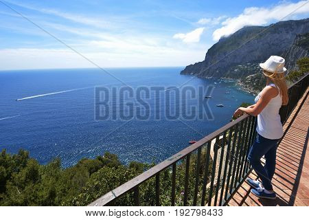 Woman in hat near fence in mountains