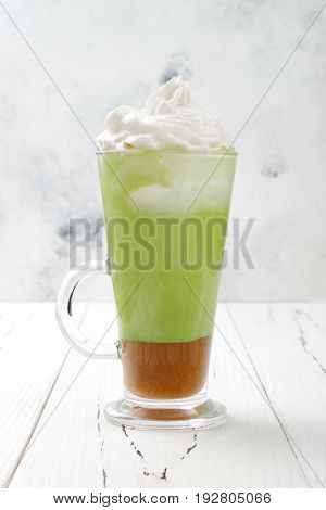 Matcha latte with salted caramel in tall glass.