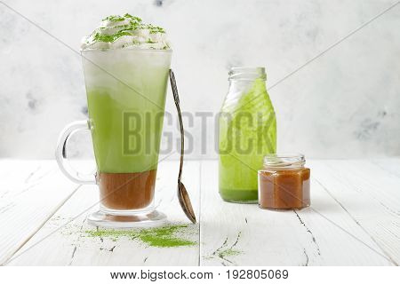 Matcha latte with salted caramel in tall glass. Copy space