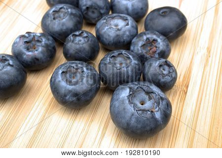 Fresh and ripe  blueberries on bamboo cutting board.