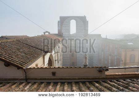 Italy Siena - December 26 2016: the view of the tiled roofs and incomplete facade of the planned Duomo nuovo in fog. Facciatone on December 26 2016 in Siena Tuscany Italy.