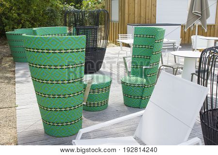 Restaurant with green wicker chairs tables and different chairs