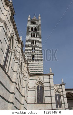 Italy Siena - December 26 2016: the view of Duomo di Siena bell tower. Metropolitan Cathedral of Santa Maria Assunta in a sunny day on December 26 2016 in Siena Tuscany Italy.