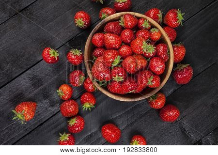 Strawberries on bllack wooden background. Copy space. Top view