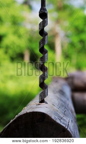 Metal spiral drill for making holes in logs when assembling a wooden frame and building a house.