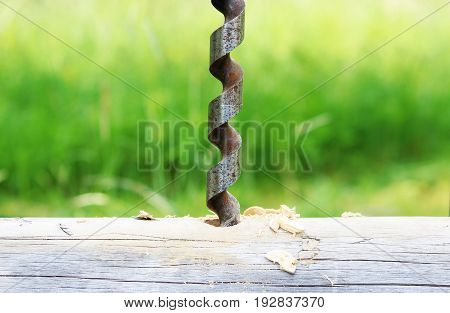 Metal spiral drill for making holes in logs when assembling a wooden frame and building a house.