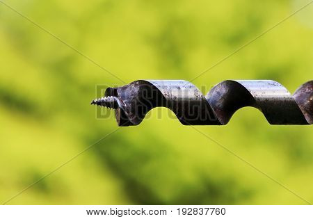 Metal spiral drill for making holes in logs when assembling a wooden frame and building a house.