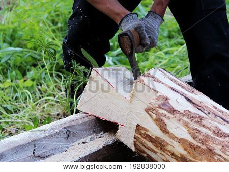 The worker collects a wooden frame with the help of an hacket during the construction of a house.