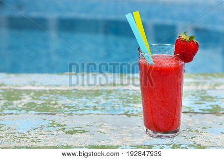 Strawberry smoothie on old rusric turquiose background near pool