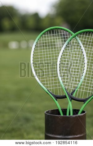 Close-up view of two badminton racquets in container outdoors