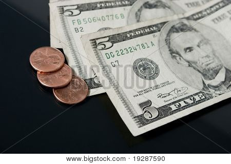 アブラハム ・ リンカーンと通貨の組み合わせ。3 つのペニーと 2 つ目に見える 5 ドル紙幣。Criti
