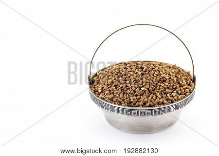 Raw buckwheat in rare silver pial isolated on white background